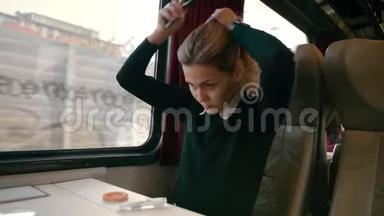 年轻的白种人女孩乘坐豪华的城际火车车厢。 使发型不留头发。 如何成为
